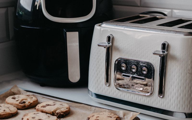 Modern air fryer and toaster on a kitchen counter with freshly baked cookies — air fryer buying guide Uganda