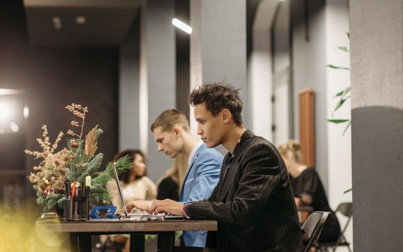 Two men working with laptops in a modern office — business laptops for professionals in Uganda