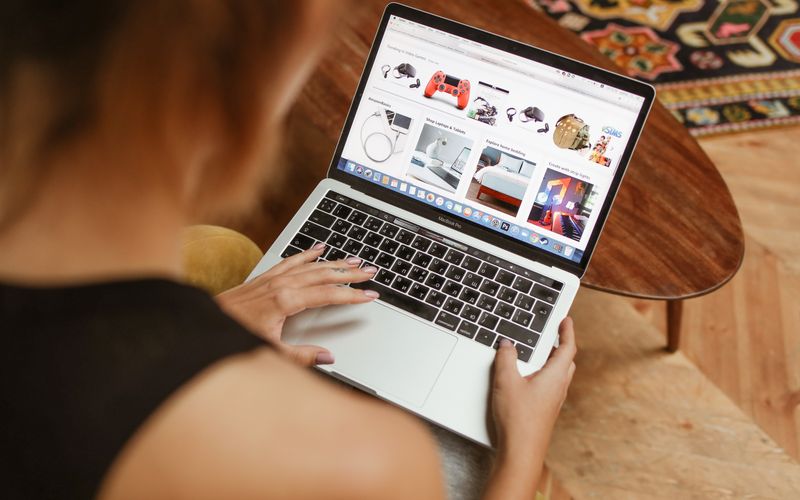 Person shopping online using a laptop with credit card — laptop installment buying guide Uganda
