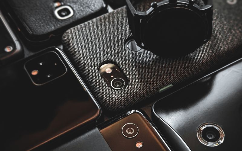 Multiple smartphones and gadgets arranged on a surface, representing affordable phone options