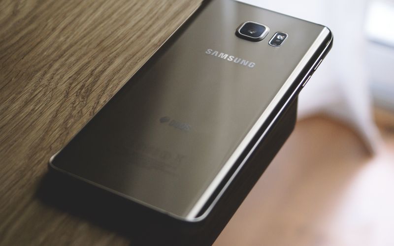 Sleek Samsung smartphone placed on a wooden surface, capturing modern mid-range elegance