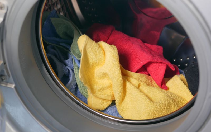 Vibrant close-up of multicolored towels inside a front-loading washing machine
